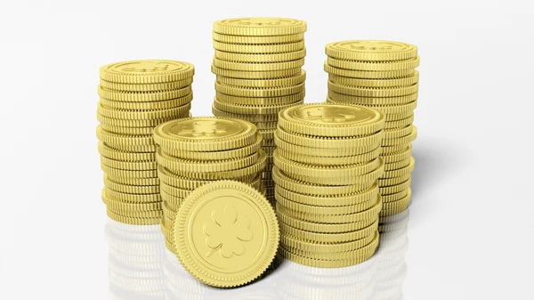 Stosy monet złotych z koniczyna liść na białym tle. — Zdjęcie stockowe