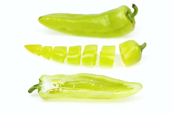 Three pointy green pepper, one half and one cut into pieces, on white background. — Stock Photo, Image