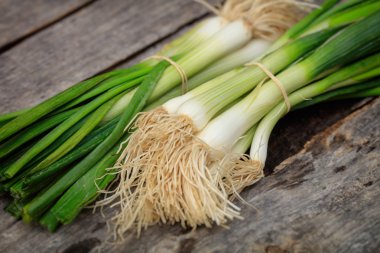 Scallions yığın, ahşap yüzeyde yeşil