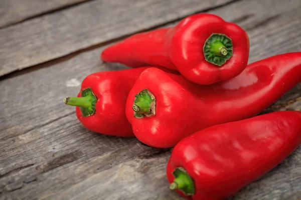 Stack of red pointy peppers, on wooden surface — Stock Photo, Image