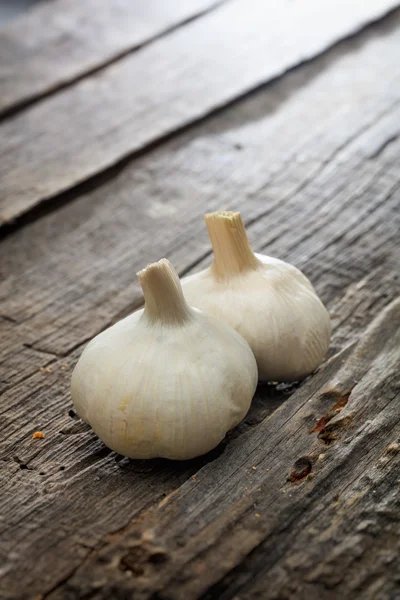 Two garlic bulbs, on wooden surface — Stock Photo, Image