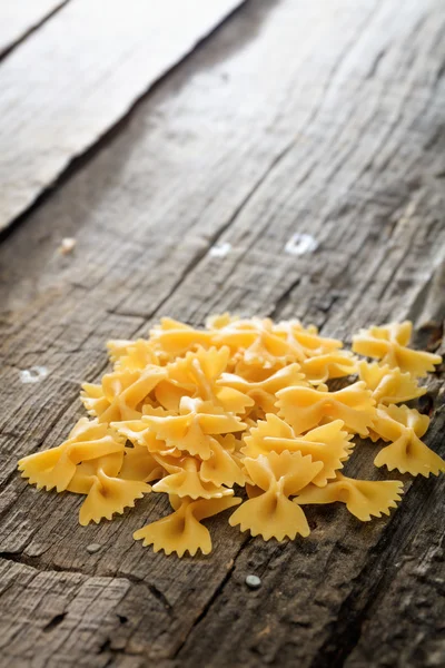 Högen av farfalle pasta, på träytan — Stockfoto