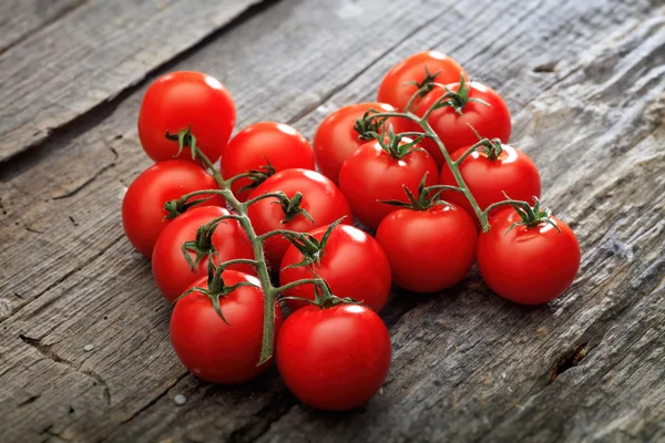 Dos racimos de tomates rojos cereza, en la superficie de madera —  Fotos de Stock