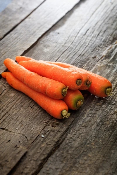 Stack av färska orange morötter, på träytan — Stockfoto