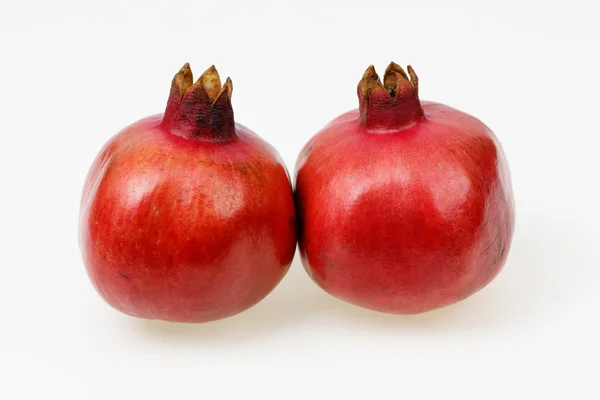 Dois frutos de romã vermelha fresca, no fundo branco . — Fotografia de Stock