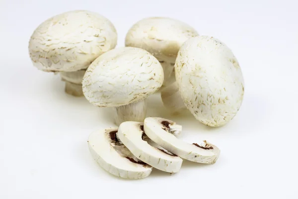 Bunch of button mushrooms with some slices, on white background. — Stock Photo, Image