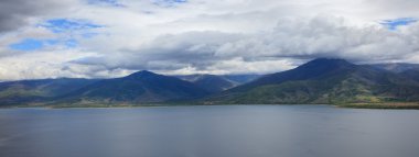 Bulutlu gökyüzü altında pastoral manzara