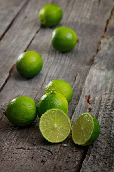 Limes éparpillés sur une table en bois — Photo
