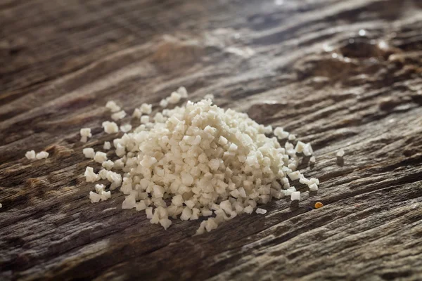 Белая серая соль на деревянном столе — стоковое фото