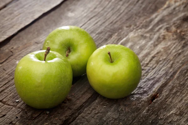 Manzanas verdes, sobre superficie de madera . —  Fotos de Stock