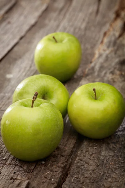Manzanas verdes, sobre superficie de madera . —  Fotos de Stock