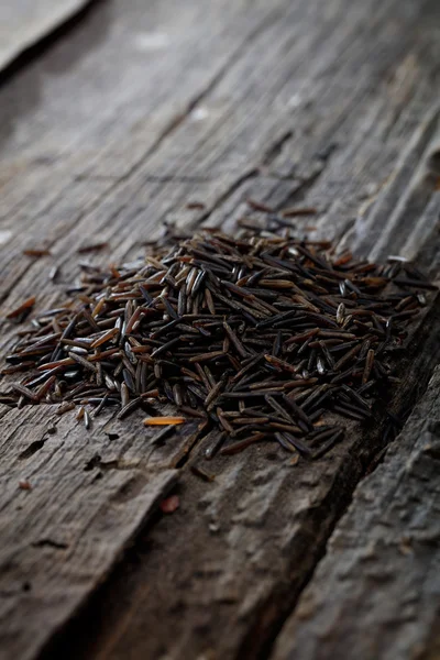 Wild brown rice, on wooden surface. — Stock Photo, Image