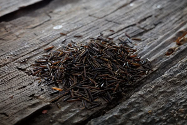 Wild brown rice, on wooden surface. — Stock Photo, Image