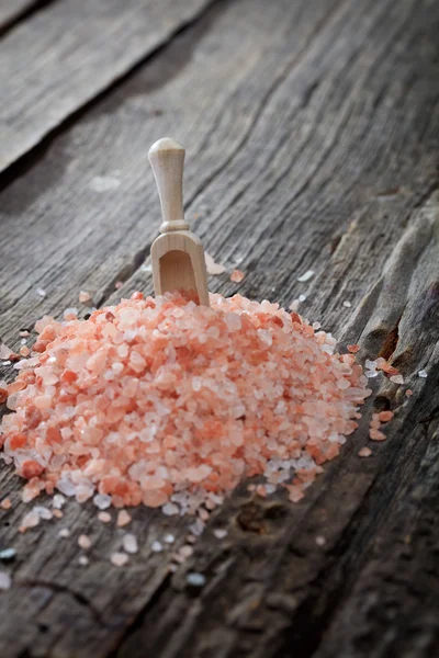 A heap of pink Himalayan salt, on wooden surface. — Stock Photo, Image