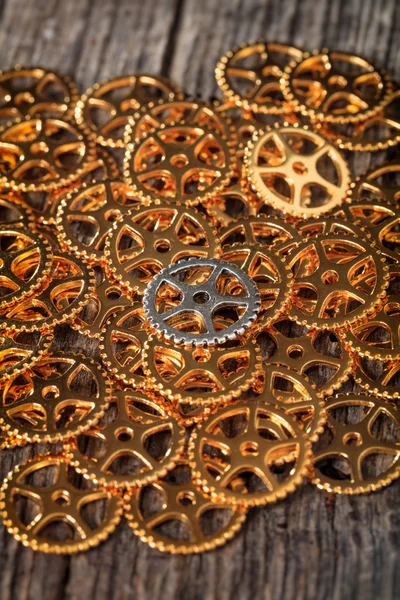 Closeup kovová ozubená hromady, na dřevěné desce — Stock fotografie