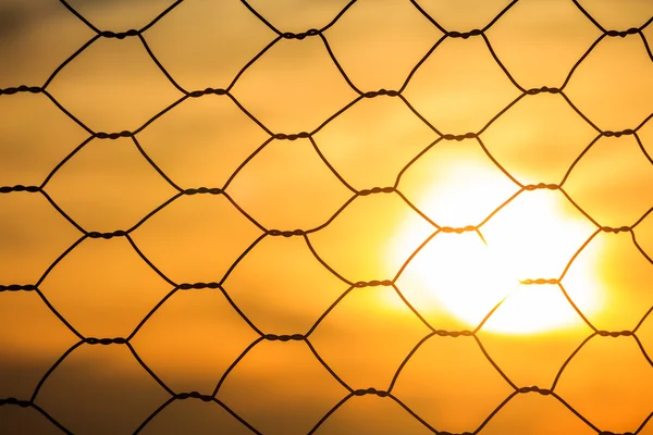 Metalen hek tegen van felle zon schijnt — Stockfoto