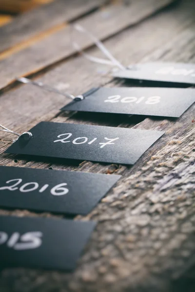 Prijzen van tags in een rij met "2017" focus en andere tekst van het jaar op houten achtergrond — Stockfoto