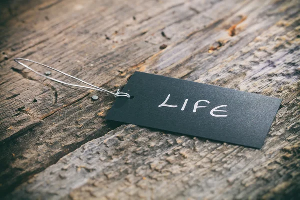 Primer plano de la etiqueta de precios con cordel y texto "Vida" sobre fondo de madera —  Fotos de Stock