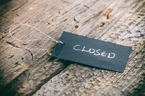 Closeup of pricing tag with twine and "Closed" text on wooden background — Stock Photo, Image