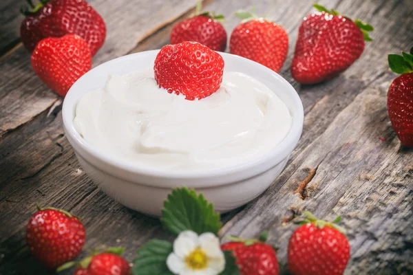 Creamy yogurt with strawberries, on wooden surface. — Stock Photo, Image