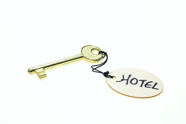 Στρογγυλή ξύλινη ετικέτα με το "Ξενοδοχείο" κείμενο σε ένα κλειδί, που απομονώνονται σε λευκό φόντο — Φωτογραφία Αρχείου