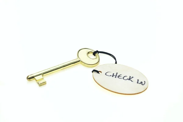 Round wooden tag with "Check in" text on a key, isolated on white background — Stock Photo, Image