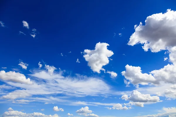 Blauwe lucht met witte pluizige wolken achtergrond. — Stockfoto