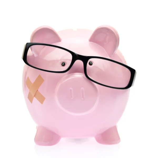 Piggy bank with eyeglasses and bandage — Stock Photo, Image