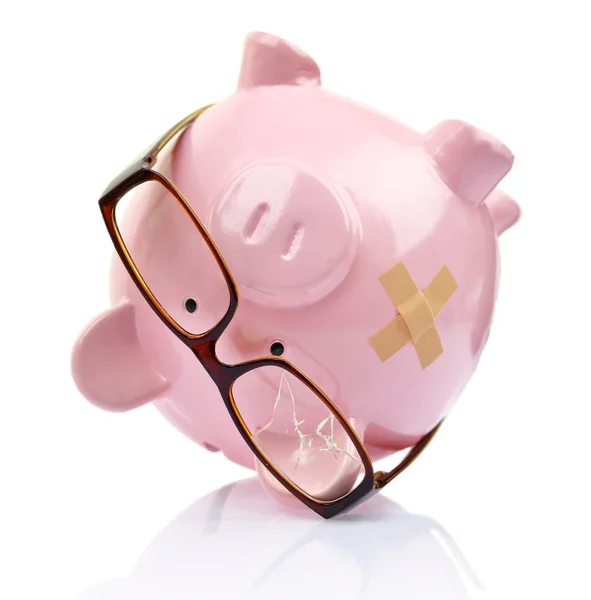 Piggy bank with broken eyeglasses and bandage upside down — Stok fotoğraf