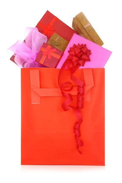 Geschenkboxen in einer roten Einkaufstasche auf weißem Hintergrund — Stockfoto