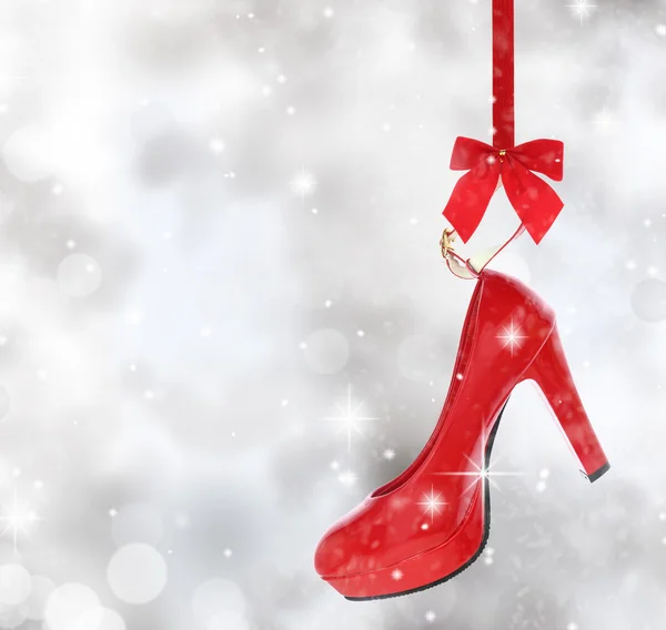 High heel shoe hanging on red ribbon — Stock Photo, Image