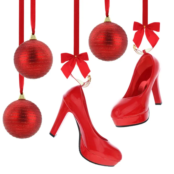 Zapatos de tacón alto y bolas de Navidad colgando de cinta roja — Foto de Stock