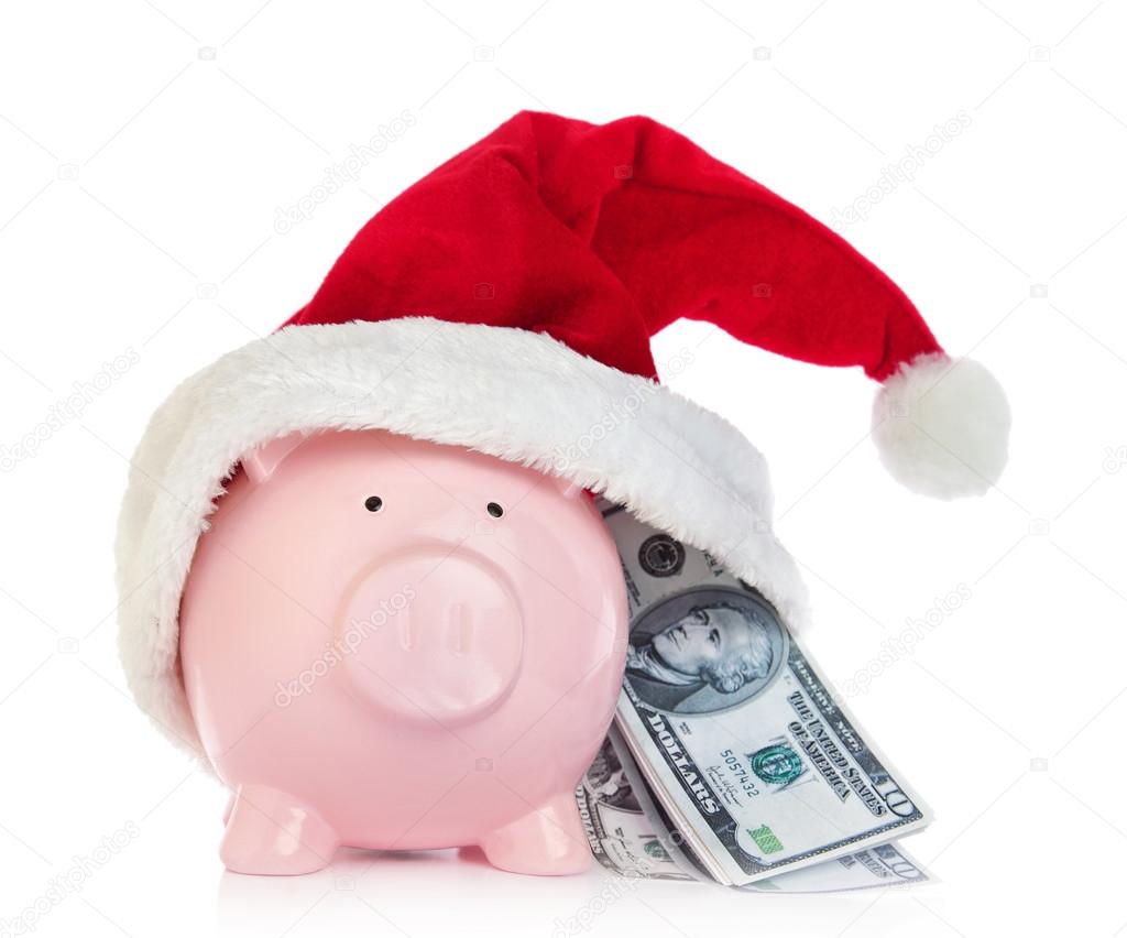 Piggy bank with Santa Claus hat and money on white background