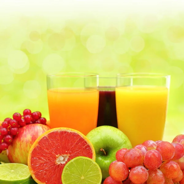 Fruta fresca y tres vasos llenos de jugo — Foto de Stock