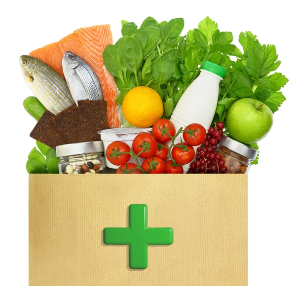 Papperskasse med medicinska grönt kors fylld med hälsosamma livsmedel — Stockfoto