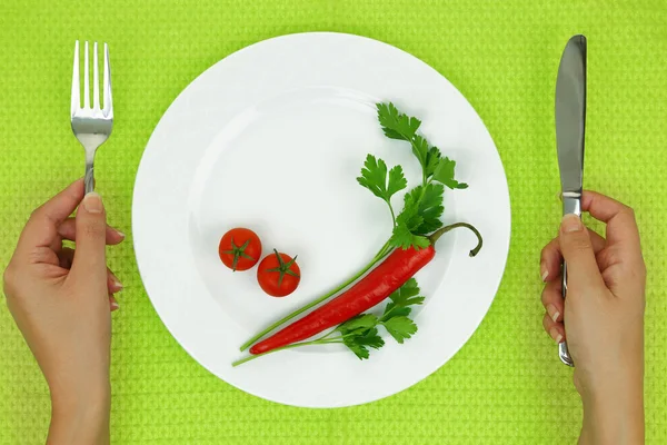 Handen en plaat met groenten op tafel — Stockfoto