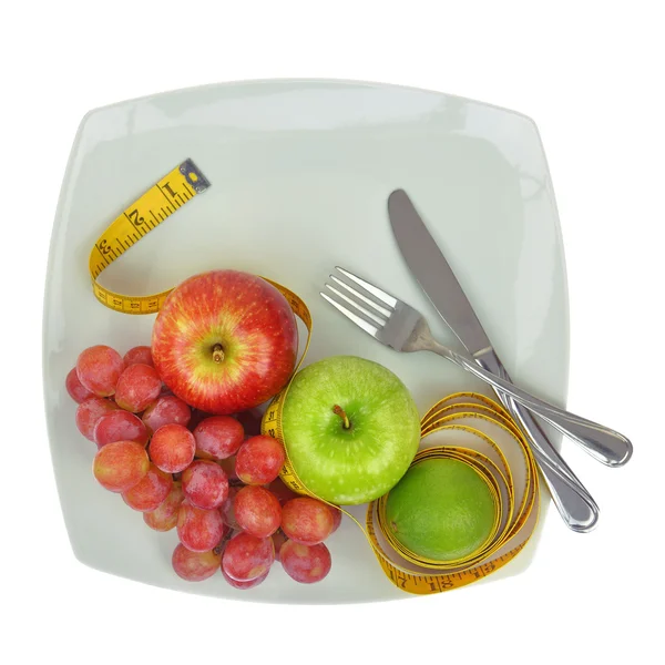 Frutas frescas e fita métrica em um prato — Fotografia de Stock