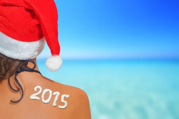 Mujer con sombrero de santas y 2015 escrito en su espalda — Foto de Stock