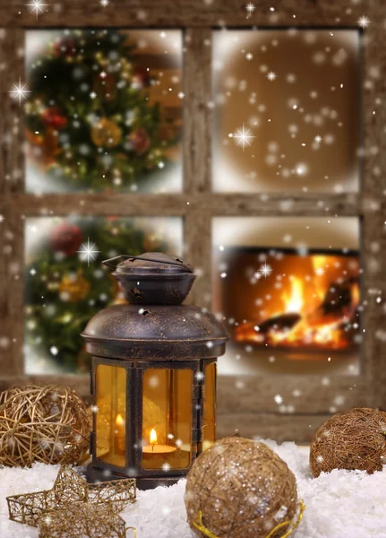 Christmas lantern and ornaments on snow in front of a window — Stock Photo, Image