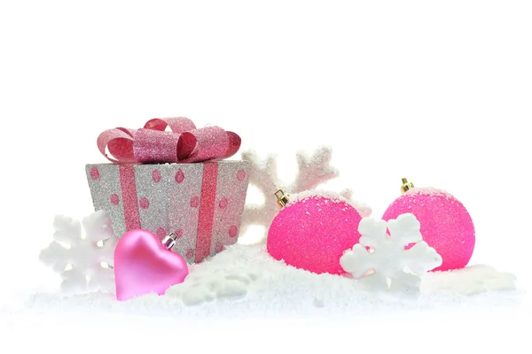 Ajándék doboz és rózsaszín karácsonyi díszek a hó — Stock Fotó