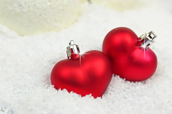 Dois enfeites de Natal em forma de coração na neve — Fotografia de Stock