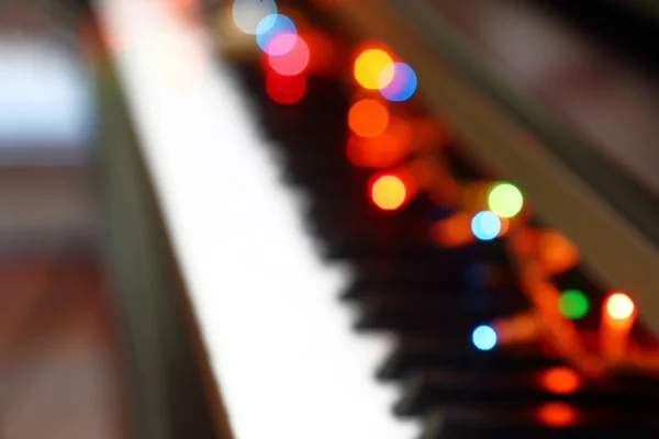 Abstracte kerst muzikale achtergrond met piano en verlichting. — Stockfoto