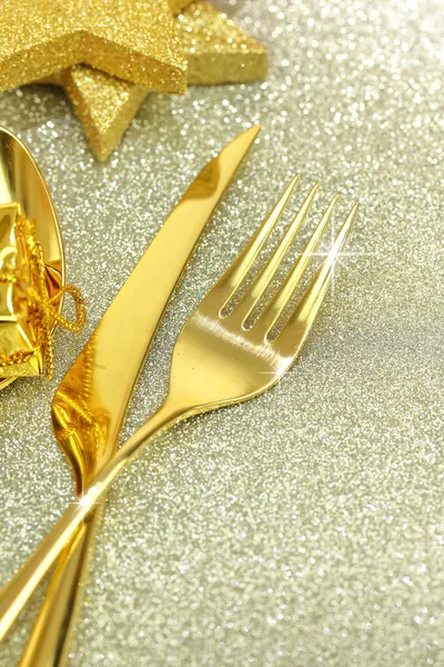 Christmas golden cutlery and ornaments on festive background — Stock Photo, Image