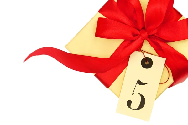 Coffret cadeau avec arc rouge et étiquette avec le numéro cinq isolé sur blanc — Photo