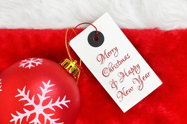 Bola de Navidad y tarjeta de felicitación en piel de santas —  Fotos de Stock