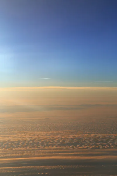 Cielo azul sobre la superficie de nubes anaranjadas, fotografía aérea —  Fotos de Stock