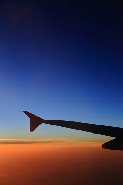 Pencereden dışarı günbatımı gökyüzü ve uçakların kanat görünümü — Stok fotoğraf