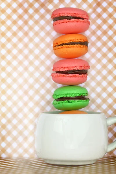 Традиційні французькі барвисті макаруни в чашці на ретро фоні — стокове фото