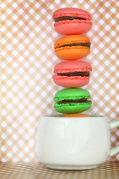 Macarrones coloridos franceses tradicionales en taza sobre fondo retro —  Fotos de Stock