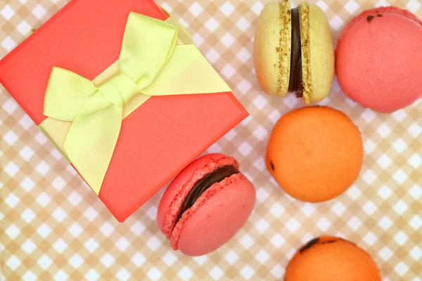 Traditionelle französische bunte Makronen mit Geschenkbox auf Retro-Hintergrund — Stockfoto